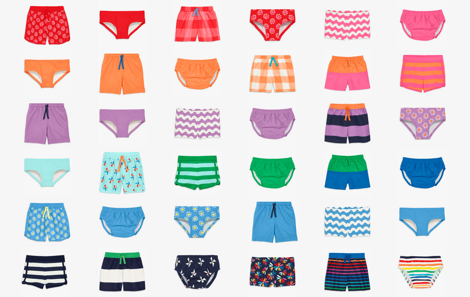 A grid of 36 swim bottoms in a rainbow order including swim trunks, board shorts, bikini bottoms, shorties, and swim diapers