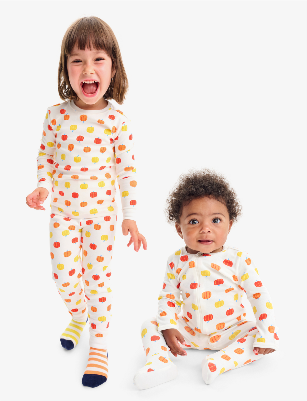 Child and baby wearing organic pumpkin print PJs